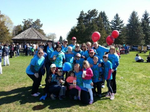 A Team in blue shirts holding balloons at the Imagine Walk