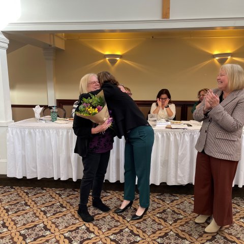 Angela Boisclair receives flowers and a hug from NEARI Executive Director Mary Barden